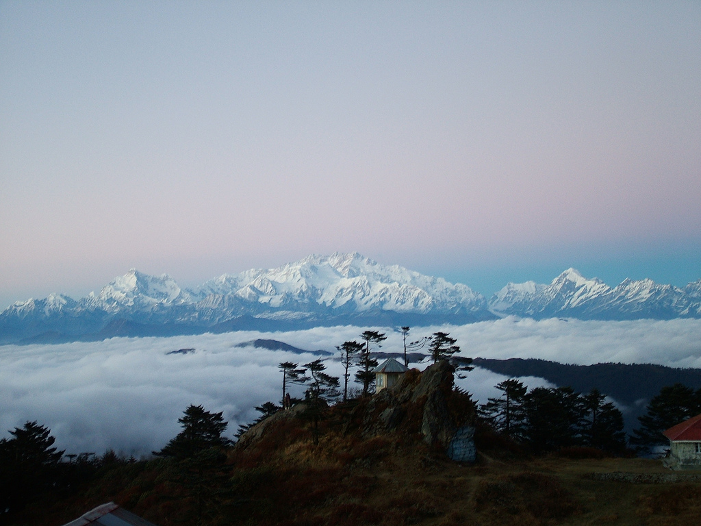 The majestic Kanchenjunga range, known as the Sleeping Buddha, glows at sunrise as seen from Sandakphu, the highest point in West Bengal—offering a surreal experience on a sustainable Himalayan trekking trail.